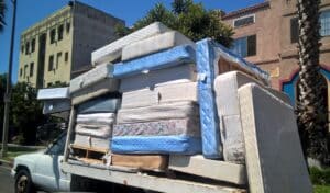 Pick up truck full of old mattresses heading to the dump