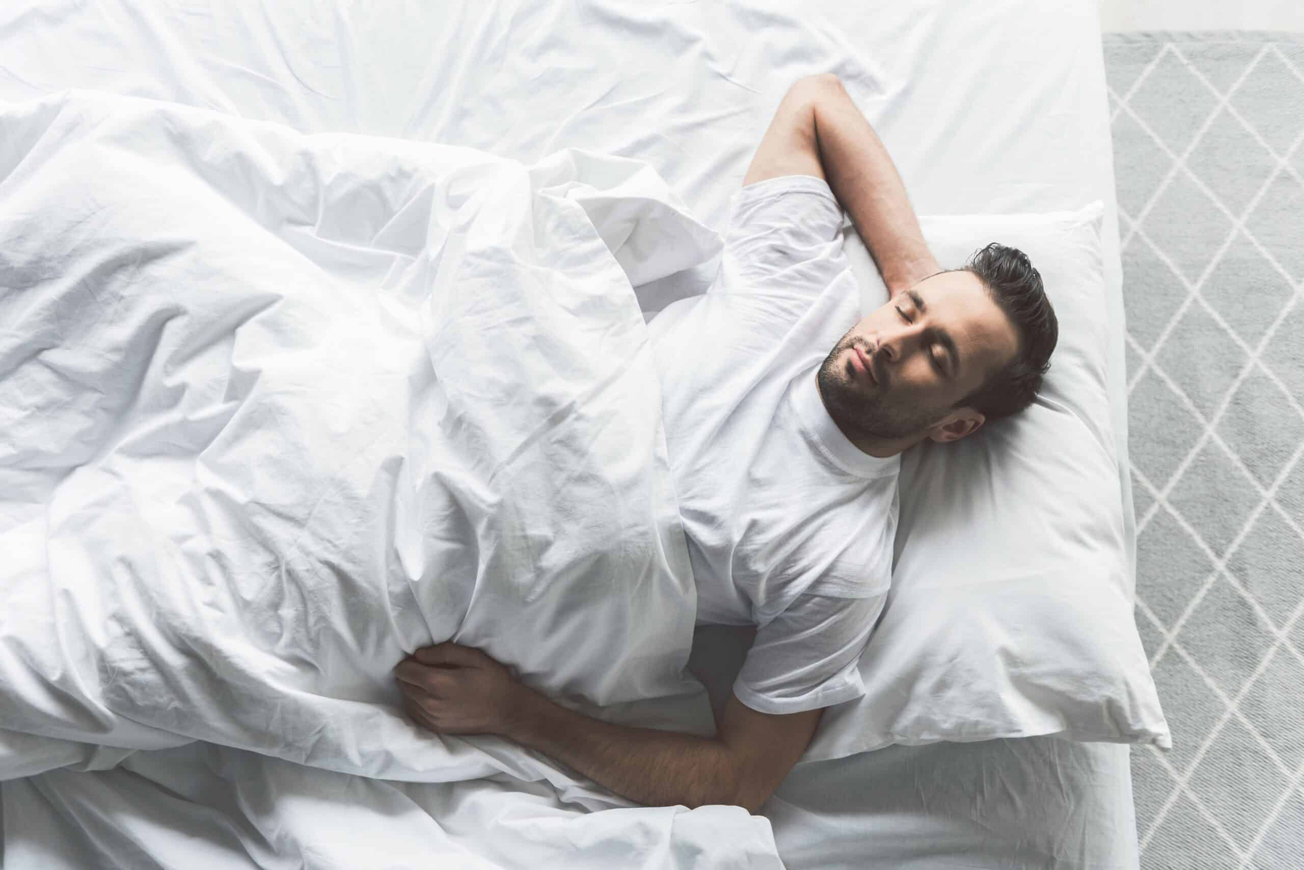 Man asleep on his back in bed_getty-images-bDcKnBBzzR4-unsplash