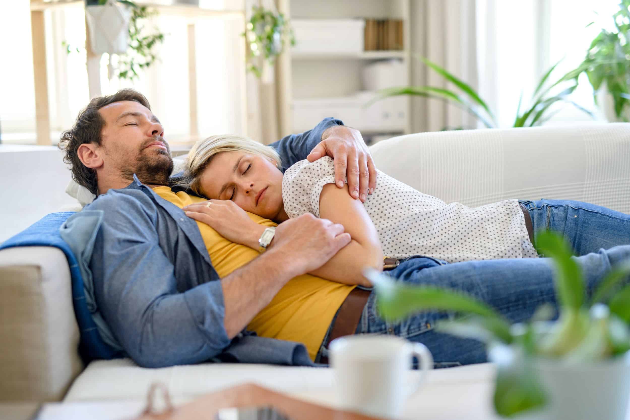 adult couple napping on a couch