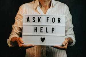 old-woman-holding-a-sign-that-says-ask-for-help