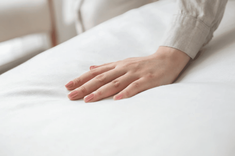 hand making impression on top of mattress