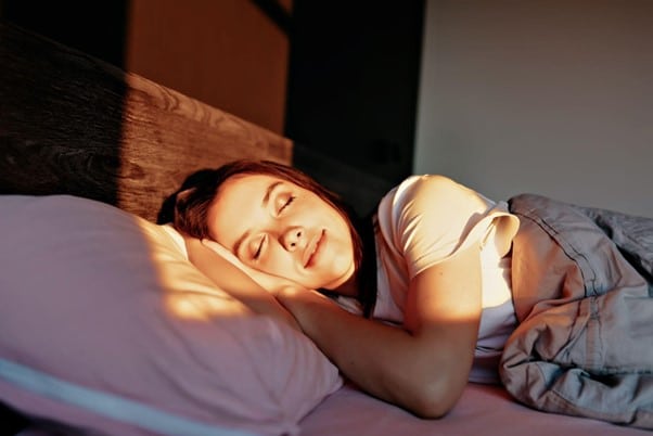 woman-smiling-while-sleeping-with-sunlight-on-her-face