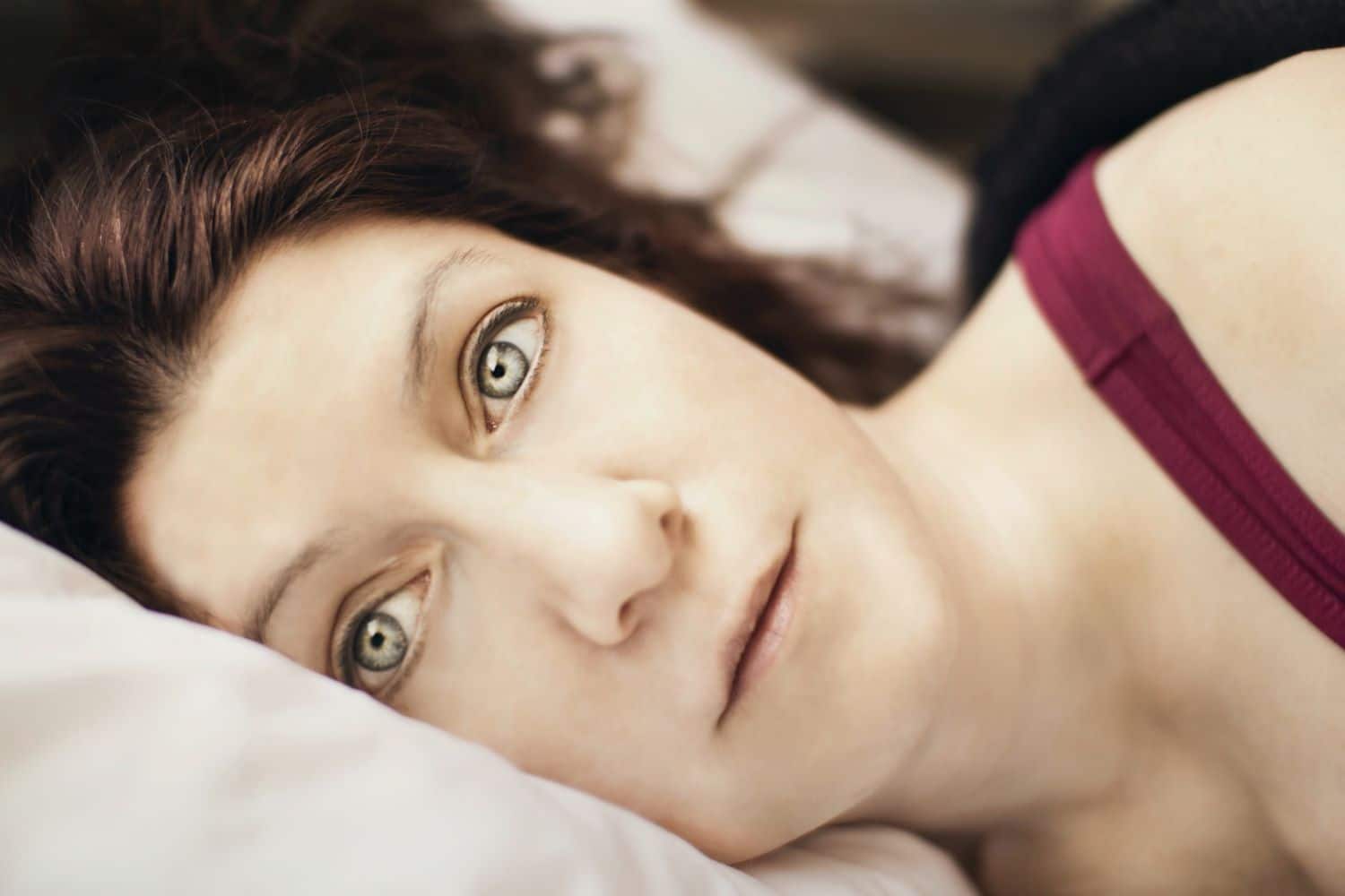 woman with insomnia lying on her side with eyes wide open
