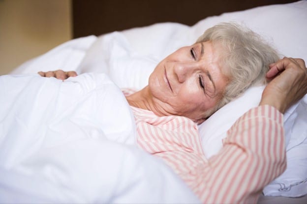 Senior woman sleeping peacefully in bed mattress